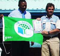 Miti, Chief Director of Metropolitan Schools of the Western Cape Education Department hands over the Green Flag to Camp Director, Terry Corr of Camp Africa Tented Eco Centre